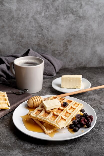 Waffles on plate with honey and butter