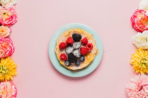 Waffles and wild berries on pink background