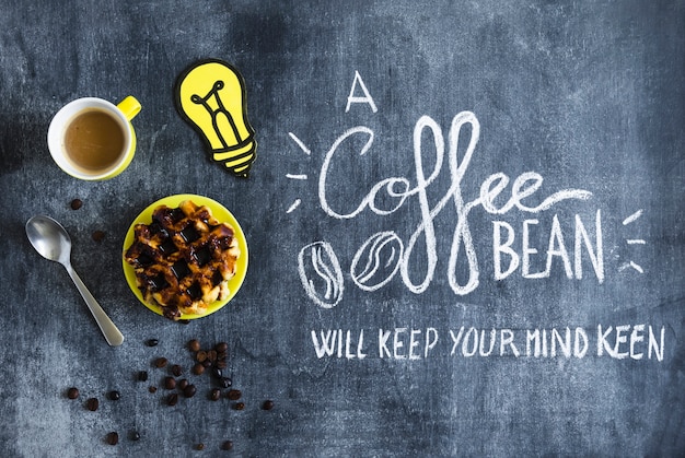 Waffles with chocolate; coffee cup and paper cutout light bulb with text on chalkboard