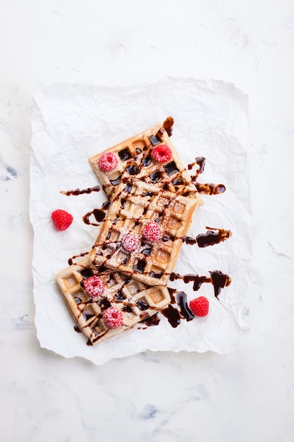 Waffles with raspberries and chocolate syrup