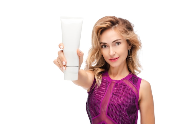 Free photo waist up of happy young holding tube of cream while looking at camera isolated on white background. copy space. beauty and care concept