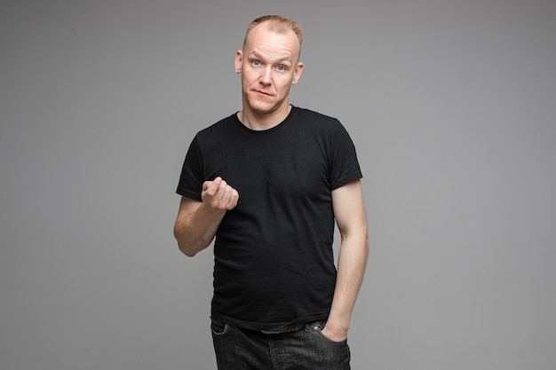 Waist-up photo of adult man in black shirt making a beaconing gesture with his hand