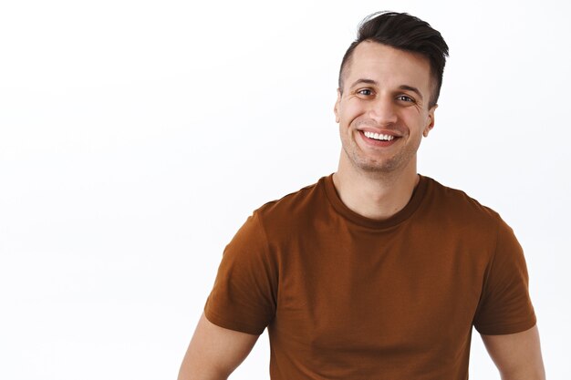 Waist-up portrait of handsome friendly-looking kind man smiling at something pleasant and adorable