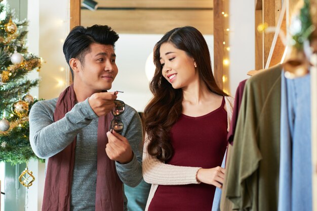 Waist up shot of Asian couple shopping checking out the sunglasses