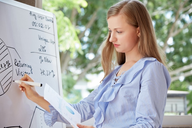 Waist up shot of Caucasian student drawing a pie diagram on the whiteboard