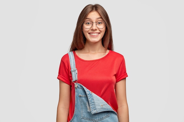 Waist up shot of fashionable girl with pleased facial expression