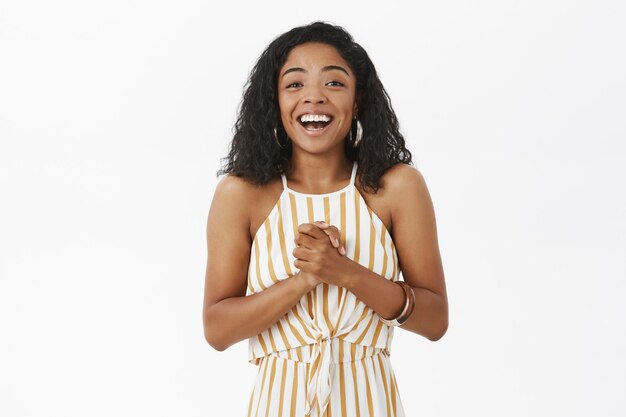 Waist-up shot of pleased and delighted happy young african american woman