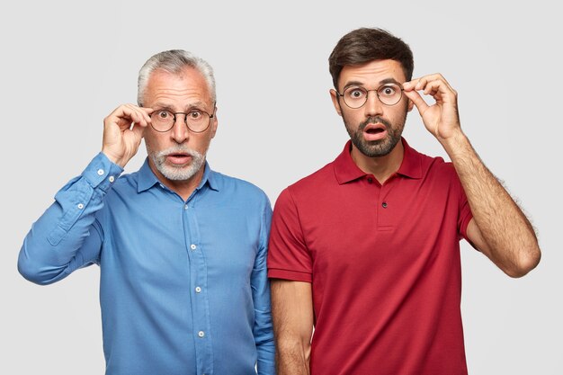 Waist up shot of two young men of different generation have uexpected gaze 