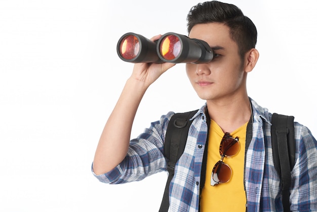 Free photo waist-up shot of young guy looking through the binocular glass