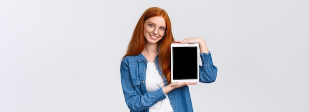 Free photo waistup attractive confident female with red hair blue eyes in glasses introduce application present