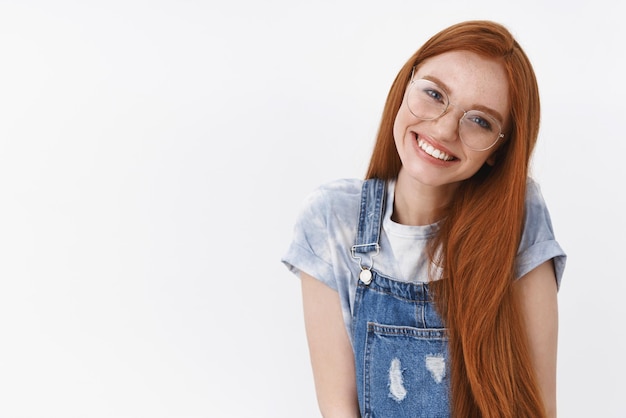 Free photo waistup friendly tender redhead caucasian girl clean pure skin long natural red hair tilt head smiling lovely look you cheerful and glad express happiness positive mood wear glasses