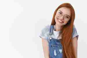 Free photo waistup friendly tender redhead caucasian girl clean pure skin long natural red hair tilt head smiling lovely look you cheerful and glad express happiness positive mood wear glasses