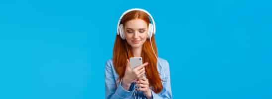 Free photo waistup portrait goodlooking foxy teenage college girl in headphones listening music scrolling news
