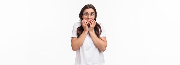 Free photo waistup portrait of scared young brunette girl in panic exams are near feel frightened biting finger