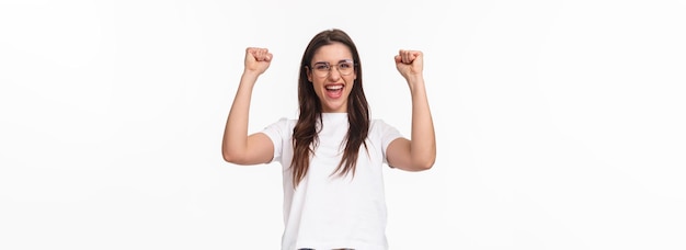 Free photo waistup portrait of talented attractive girl winning in competition fist pump raising hands up do ch