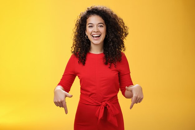 Waistup shot of assertive charming and happy young woman with curly hairstyle laughing joyfully smil...