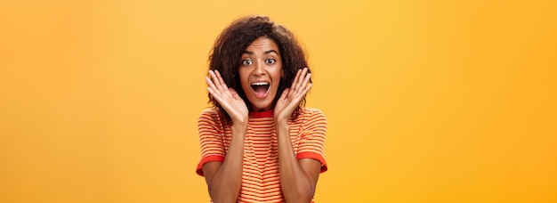 Free photo waistup shot of impressed excited talkative darkskinned woman with curly hair and perfect skin yelli