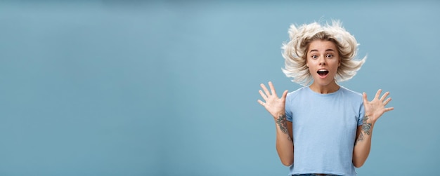 Foto gratuita impressione alla vita di una ragazza affascinante e carina con i capelli biondi che galleggia nell'aria e