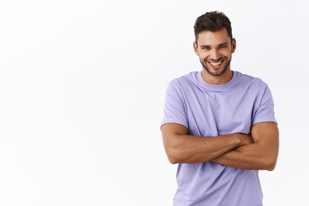 Waistup shot masculine healthy handsome caucasian man with bristle in purple tshirt cross arms over chest smiling with satisfied carefree expression having casual joyful talk