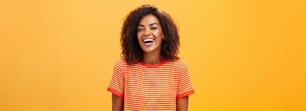 Free photo waistup shot of outgoing happy charming darkskinned female with curly hairstyle laughing joyfully