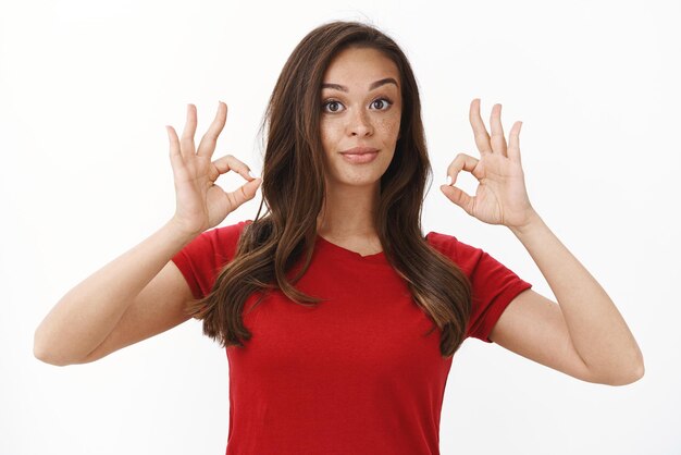 ウエストアップショットは、赤いTシャツで満足しているブルネットの女性の顧客を示しています。
