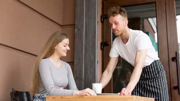 Waiter bringing coffee to woman