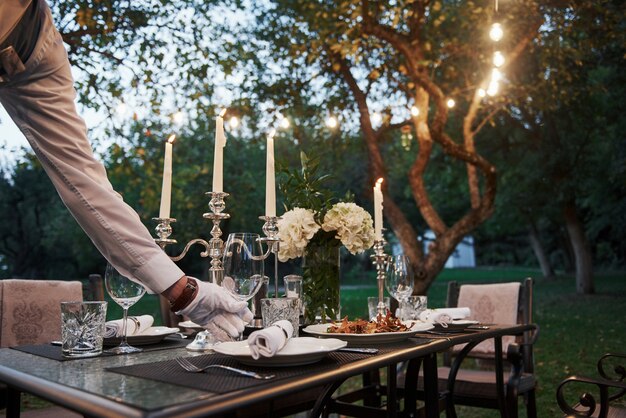 Waiter hand in the gloves. Worker is engaged in serving the table