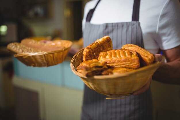 Waiter holding a basket of bread in cafÃ©