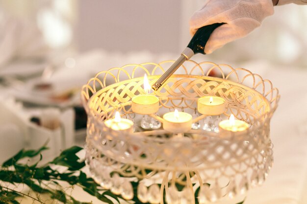 Waiter lights up candles in decorative lamp 