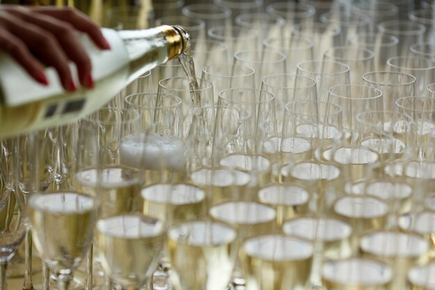 Waiter pours champagne in the glasses