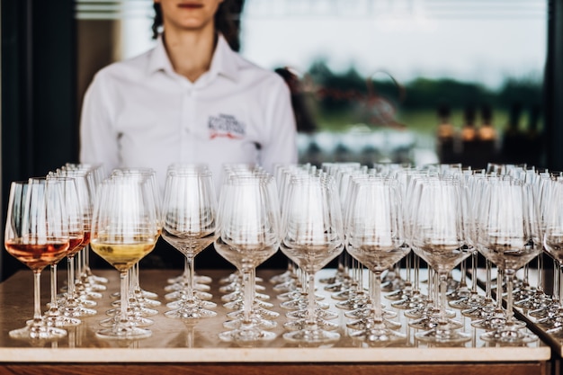 a waiter stands behind a lot of glasses