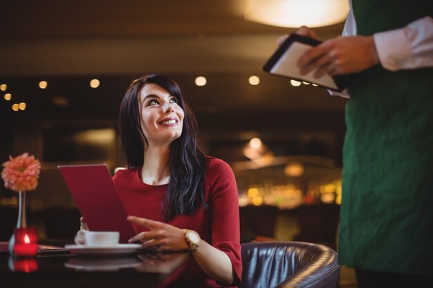 Waiter taking order from woman