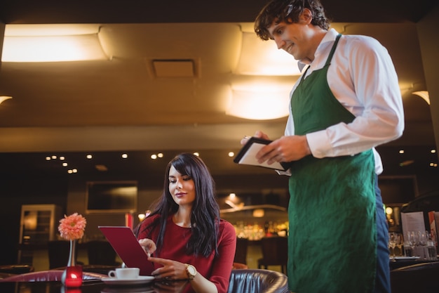 Waiter taking order from woman