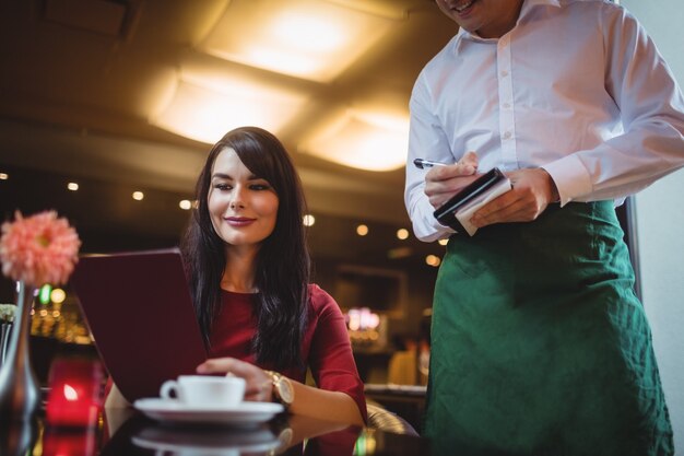 Waiter taking order from woman