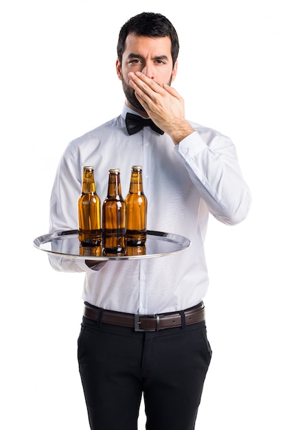 Free photo waiter with beer bottles on the tray covering his mouth