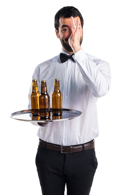 Waiter with beer bottles on the tray doing a joke