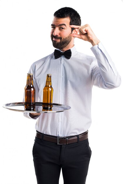 Waiter with beer bottles on the tray doing tiny sign