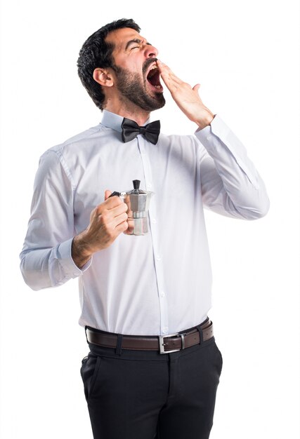 Waiter with beer bottles on the tray holding a coffee pot