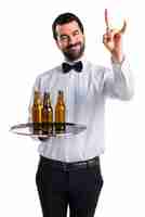Free photo waiter with beer bottles on the tray making horn gesture