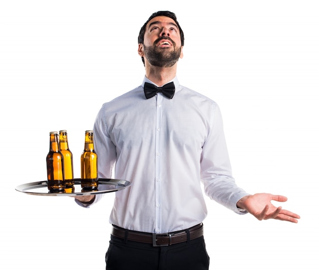 Free photo waiter with beer bottles on the tray pleading