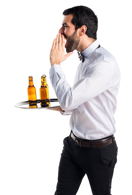 Foto gratuita cameriere con bottiglie di birra sul vassoio gridando