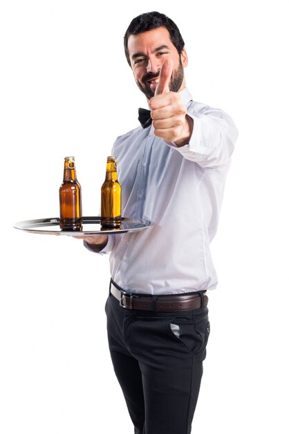 Waiter with beer bottles on the tray with thumb up