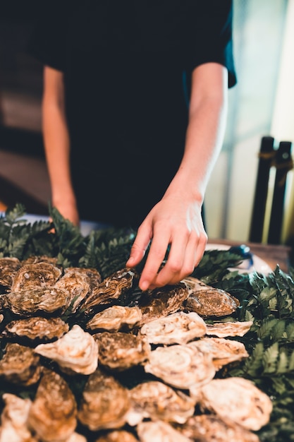 Free photo waitress arranging oyster plate