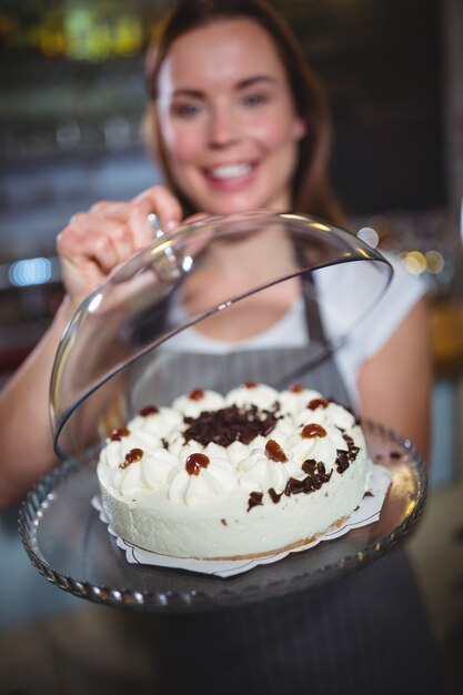 ケーキのプレートを保持するウェイトレス