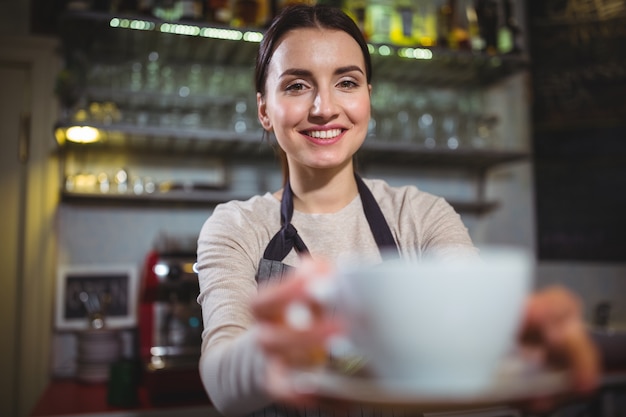 Waitress serving a cup of coffee to customer