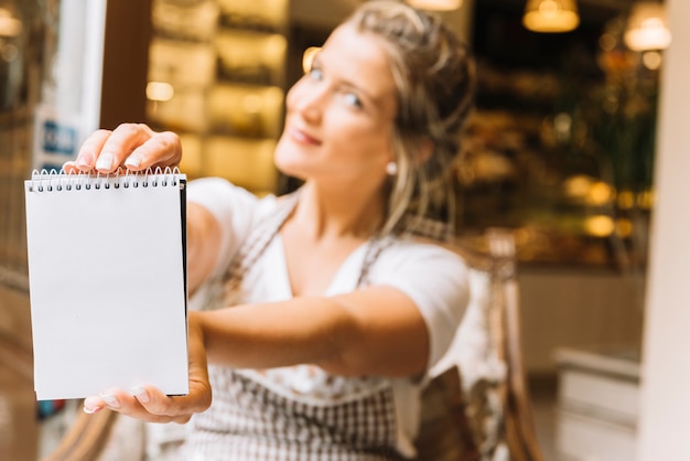 Free photo waitress showing notebook