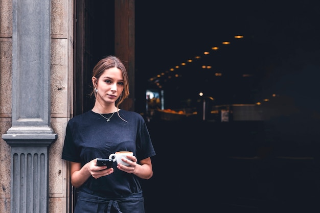 Free photo waitress with smartphone and beverage