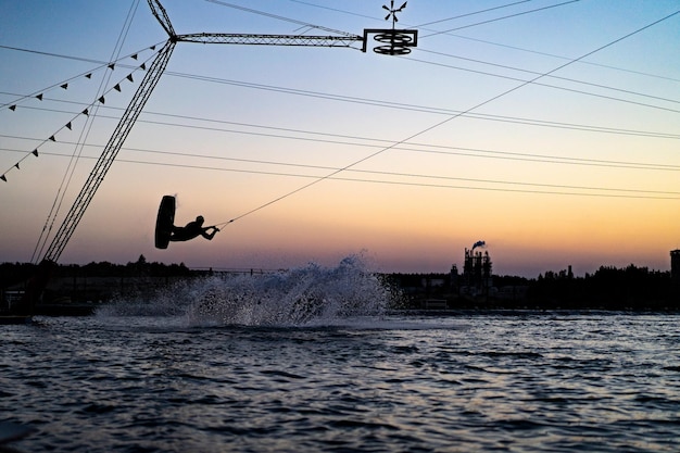 Бесплатное фото Вейкборд. вейкбординг прыгает на закате