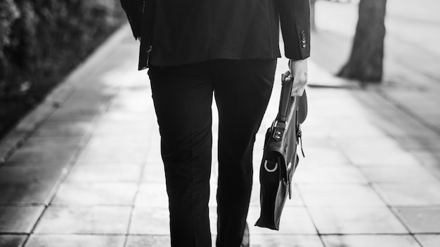 Walking business man holding his bag