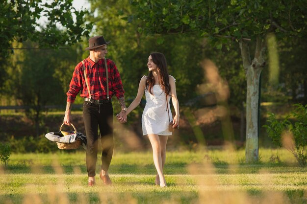 아래로 걸어. 여름날 공원에서 함께 주말을 즐기는 백인 젊고 행복한 커플